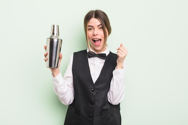 Pretty young woman feeling shockedlaughing and celebrating success cocktail barman concept