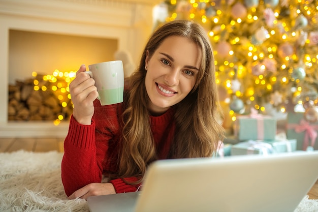 Pretty young woman having an online date and feeling pleased