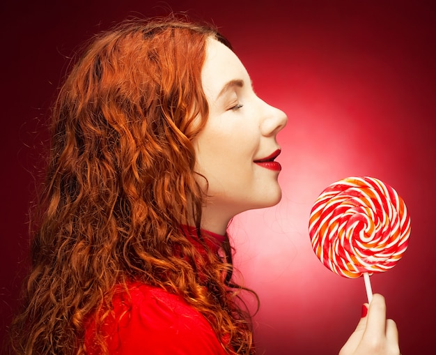 Photo pretty young woman holding lolly pop.