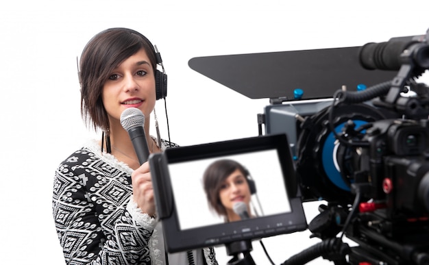 Pretty young woman  journalist presenting report in television studio on white