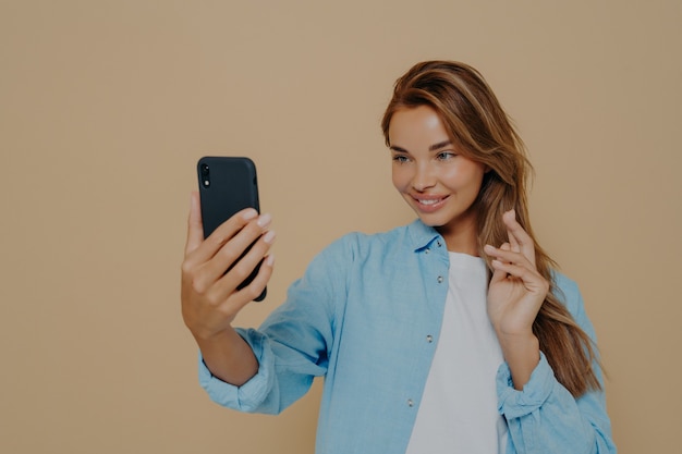 Pretty young woman makes selfie with smart phone