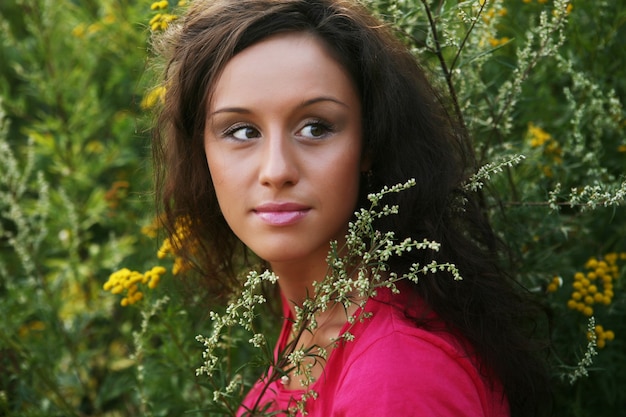 Pretty young woman outdoor in the grass in summertime