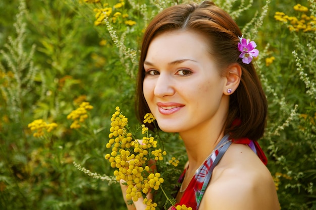 Pretty young woman outdoor in the grass in summertime