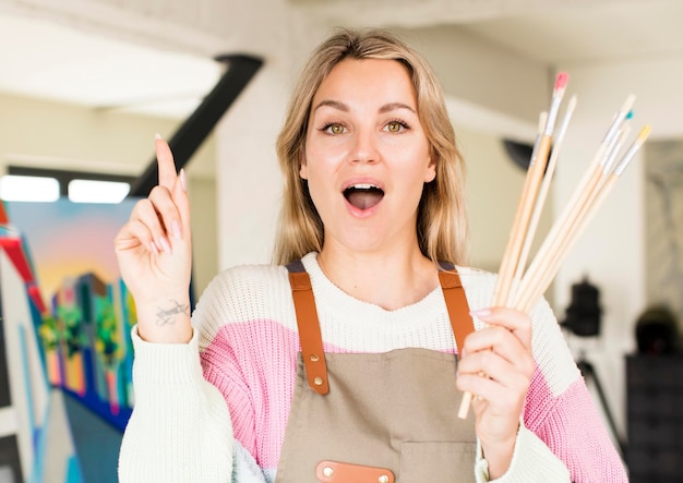 Photo pretty young woman painting an artwork artist concept house interior design