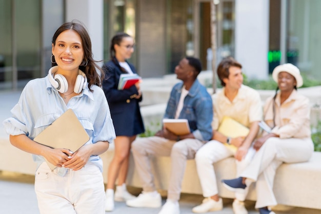 Pretty young woman posing over multiracial group of students