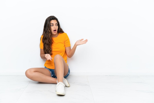 Pretty young woman sitting on the floor at indoors