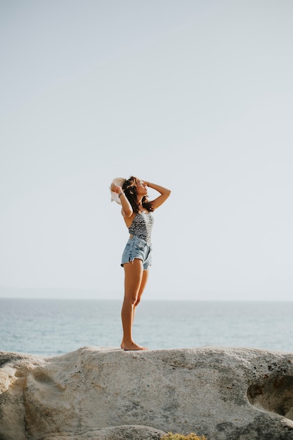 Pretty young woman on the stony shore