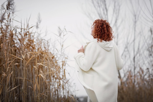 Pretty young woman in trendy white clothes poses in motion