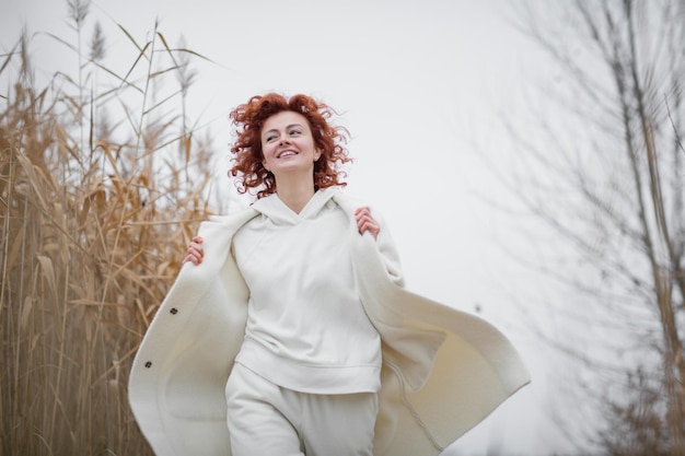 Pretty young woman in trendy white clothes poses in motion