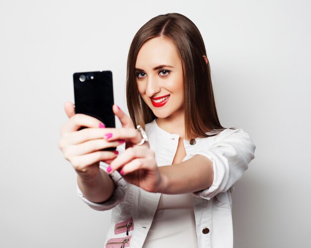 Pretty young woman using mobile phone over white background