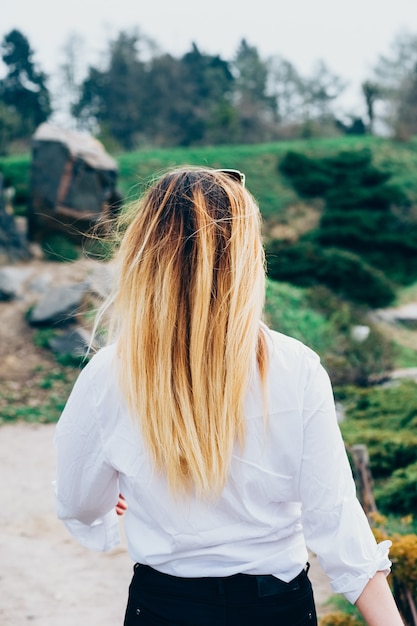 pretty young woman walking up the path in park Back view Romantic or freedom concept