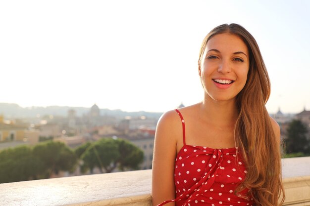 Pretty young woman with cityscape of Rome on the background, Italy