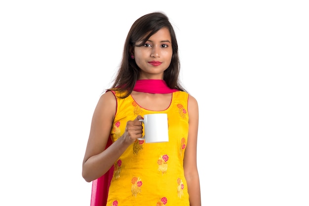 Pretty young woman with cup of tea or coffee posing