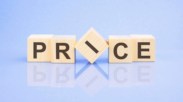 PRICE word is written on wooden cubes closeup bright blue background white surface table