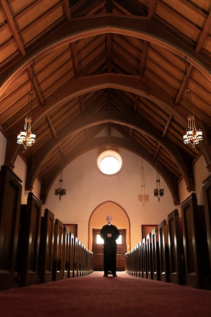 Priest praying in church