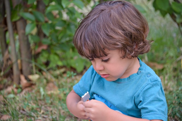 Primary school child lying on the grass doing homework