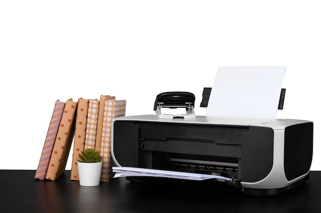 Printer and stack of books on black table against white background