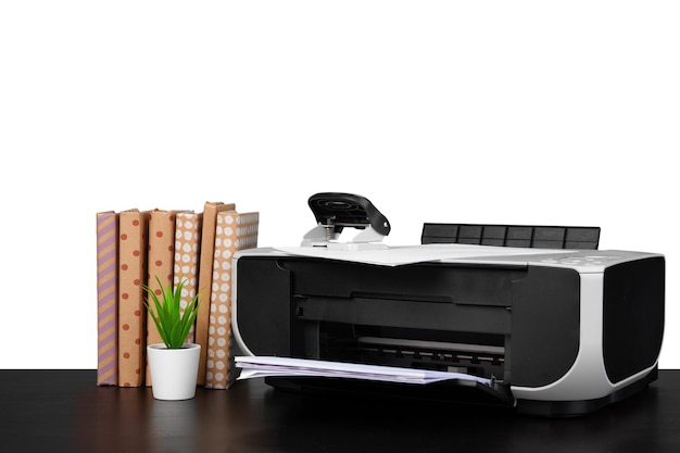 Printer and stack of books on black table against white background