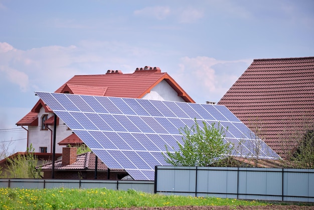 Private home with solar photovoltaic panels mounted on standalone frame on backyard ground for generating of clean ecological electric energy in suburban rural town area Concept of autonomous house