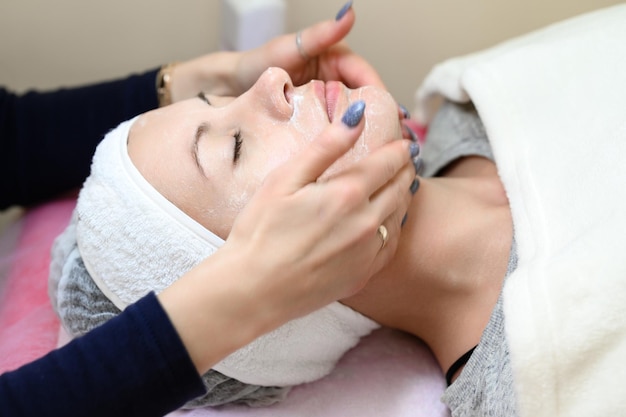 Procedure at a cosmetologist cleansing the face of cosmetics and preparing the face for massage