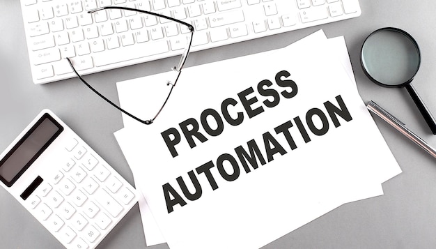 PROCESS AUTOMATION text on paper with keyboard calculator on a grey background