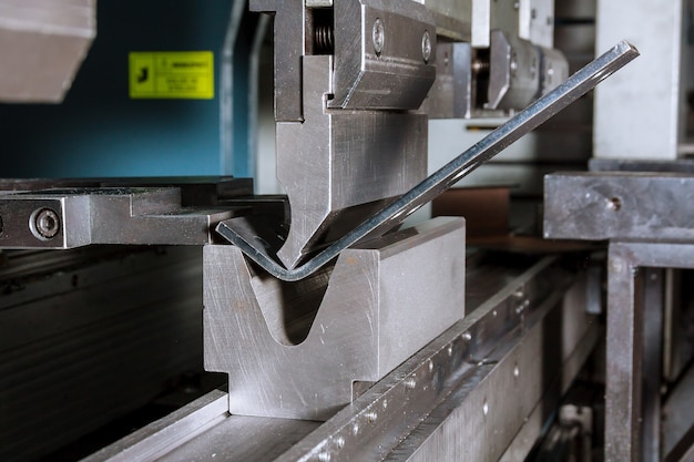 The process of bending sheet metal on a hydraulic bending machine. Metalworking plant.