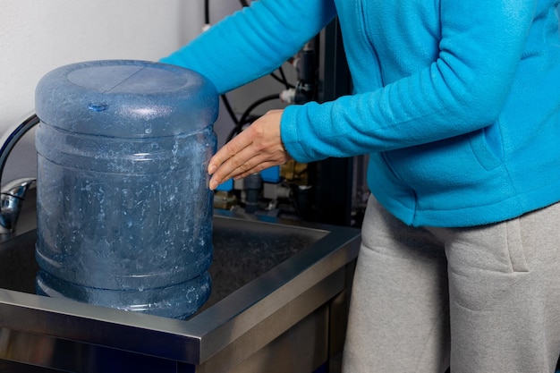 The process of cleaning the bottles before filling them with water Closeup of a woman's hands wash