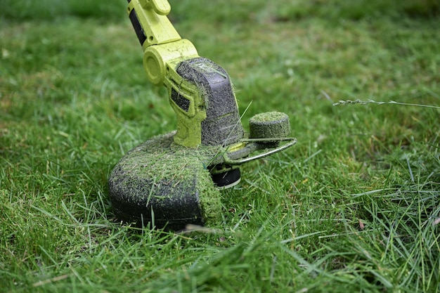 Photo process of cutting grass with a professional grass trimmer