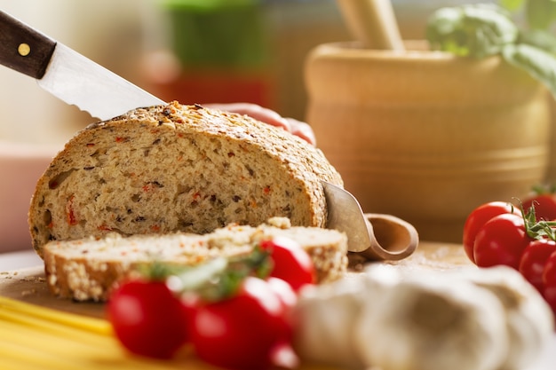 Process of cutting wholewheat bread in the kitchen. Kitchen Background. Cooking process. Horizontal.