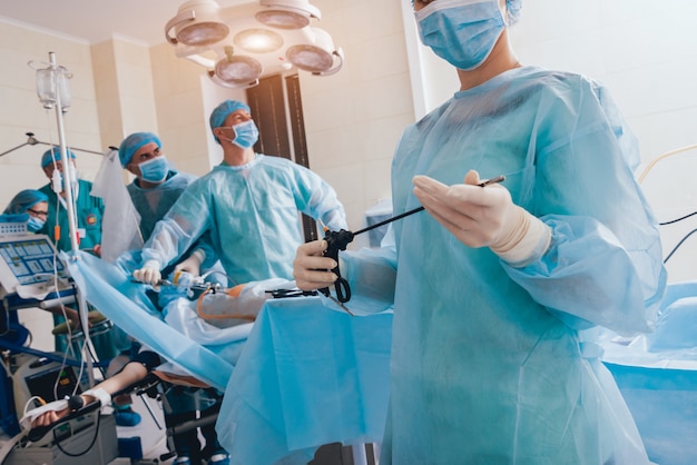 Process of gynecological surgery operation using laparoscopic equipment. Group of surgeons in operating room with surgery equipment