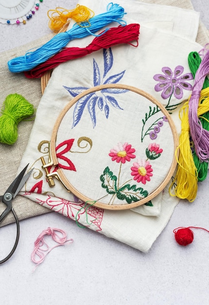 Photo the process of hand embroidering a napkin with colored threads on white fabric