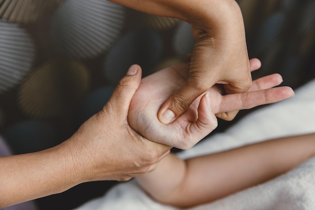 Photo process of hand massage wrist knuckle tendon stretching and acupressure for relaxation and healing in the spa for asian woman healthcare