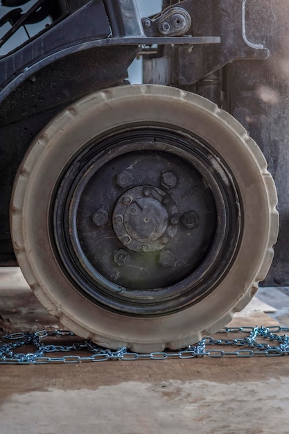 The process of installing an antiskid chain on a wheel in winter preparing a loader tractor or truck