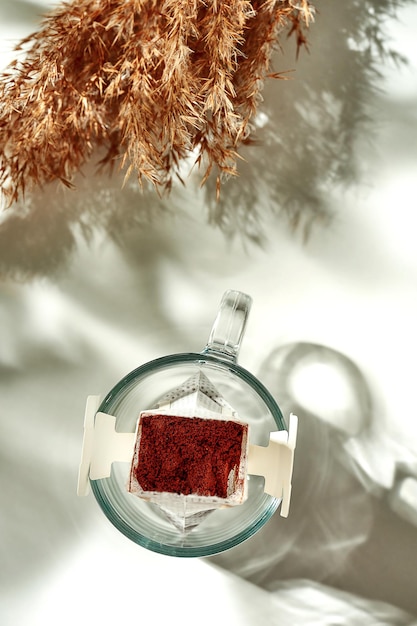 The process of making coffee drip in a transparent glass. Sunny morning breakfast. The coffee filter