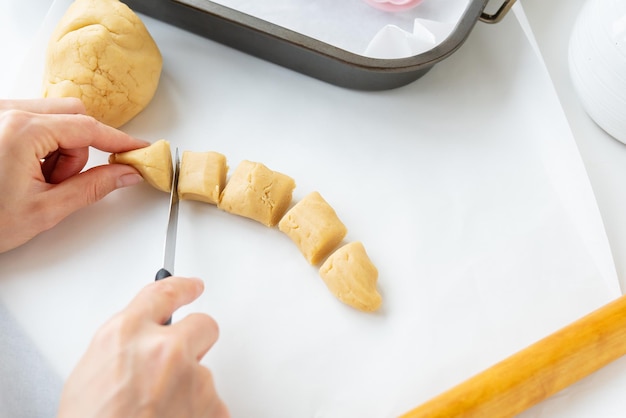 The process of making cookies with shapes in the form of flowers a rolling pin and a tray the concept of cooking baking at home