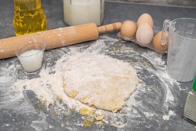 The process of making dough for a delicious khachapuri with egg on a spacious kitchen table