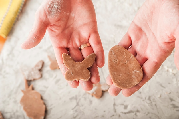 The process of making gingerbread. Hands cut gingerbread cookies closeup.