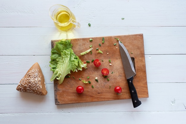 The process of making salad at home on a white background. Vegetarianism. Healthy lifestyle.