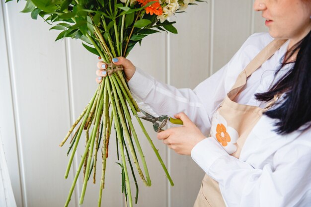 The process of pruning the stems of a bouquet with pruning shears in a flower shop