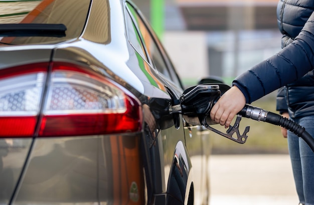 Process of refueling a car fill with petrol fuel at the gas station pump filling fuel nozzle in fuel...