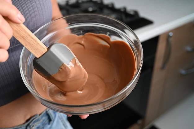 The process of tempering chocolate and making chocolates Pastry chef using spatula tempering molten chocolate