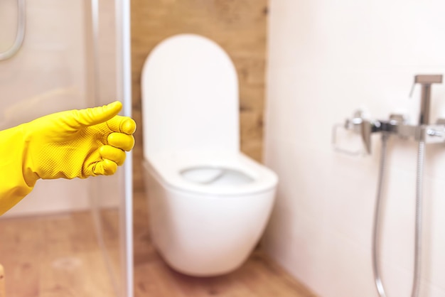 Product bottle mockup 2 hands in protective yellow gloves on bathroom background