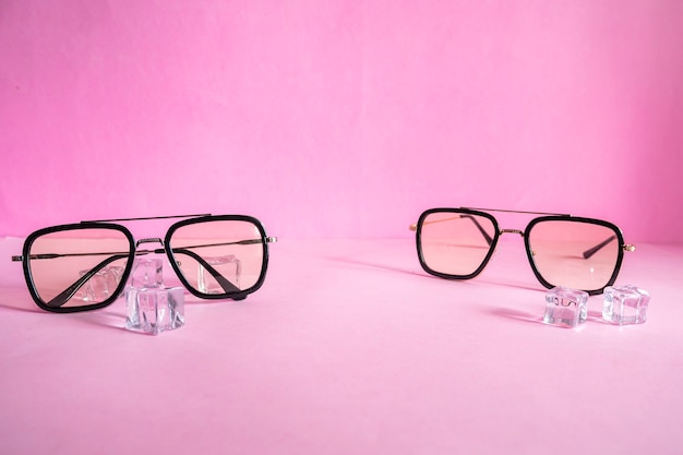 Product Presentation Minimalist Concept idea. glasses, ice cubes on pink paper background.