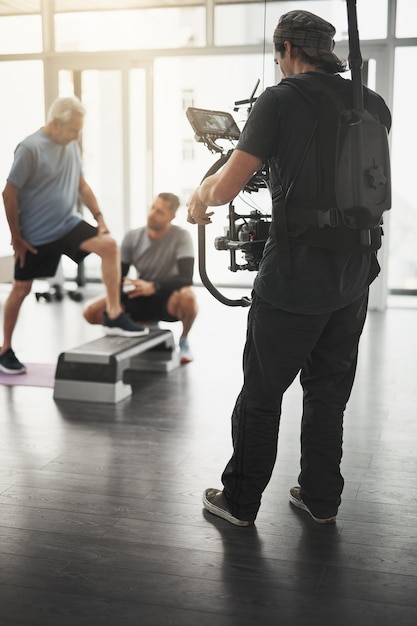 Photo production photographer and man with camera in recording for healthcare commercial and creative project clinic shooting and people with content creation for exercise service and physical therapy