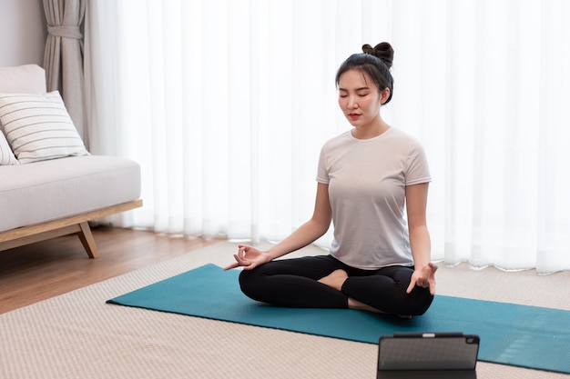 Productive activity concept a calm girl concentrating on meditating alone among peaceful atmosphere in the living room.