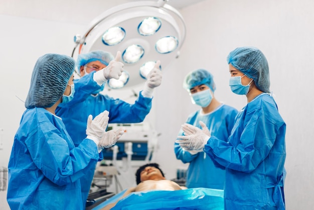 Professional anesthesiologist doctor medical team and assistant preparing patient to gynecological surgery performing operating with surgery equipment in modern hospital operation emergency room