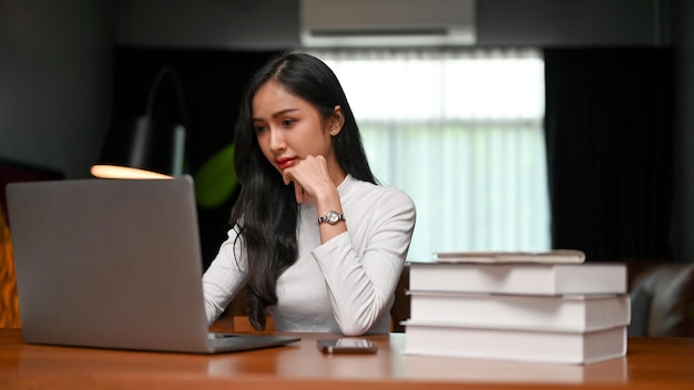 Professional Asian businesswoman browsing information on the internet using laptop