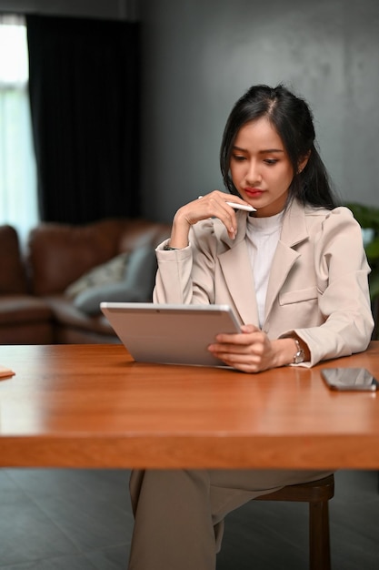 Professional Asian businesswoman concentrating on her business tasks on her tablet