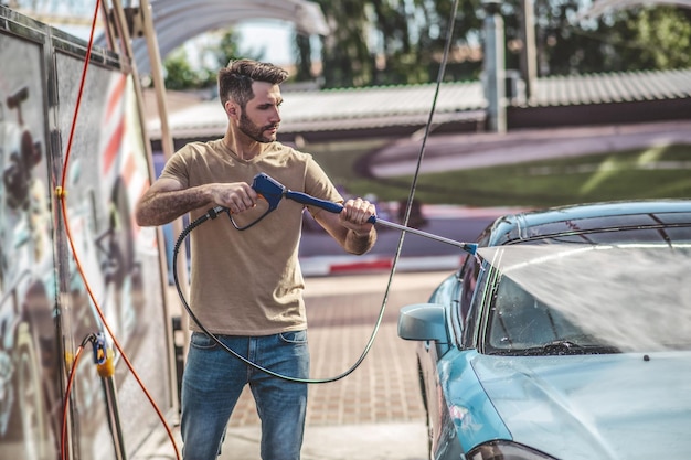 Professional auto detailer cleaning a client automobile outdoors