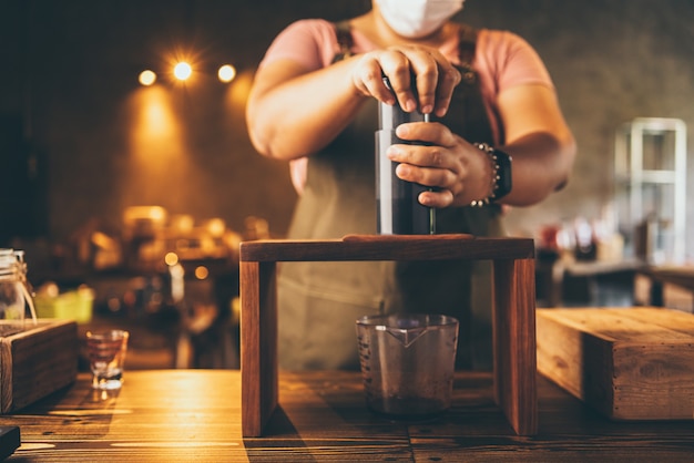 Professional barista make a fresh drink with tea and milk on cup, beverage tasty bar cafe, hand holding milk latte in coffee shop or food restaurant, bartender working in cafeteria uniform